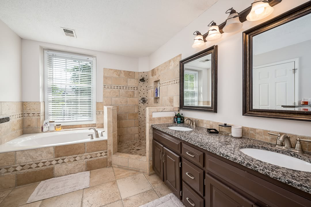 Luxurious master bathroom with dual vanity, granite countertop, soaking tub and walk-in shower
